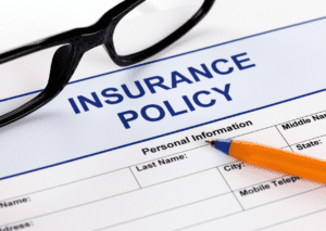 Close-up of an insurance policy form with a pen and glasses, emphasizing the importance of personal information for coverage.