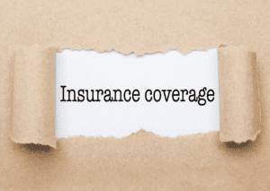 "assurance coverage" text behind torn brown paper, symbolizes the importance and protection offered by insurance policies.