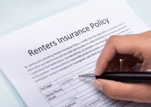 Hand filling out a Renters Insurance Policy form, emphasizing the importance of securing rental property and belongings.