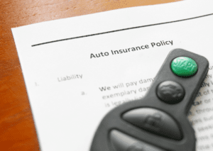 Auto insurance policy document with car remote, symbolizing vehicle coverage and protection.